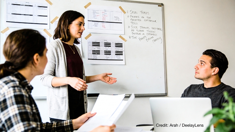 Frau präsentiert im Team-Meeting